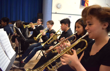  students playing the trumpet at a recital