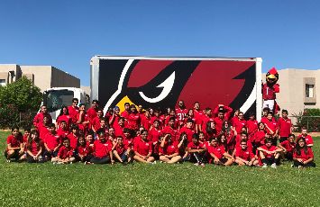  Arizona Cardinals Academy Students sit on the grass outside