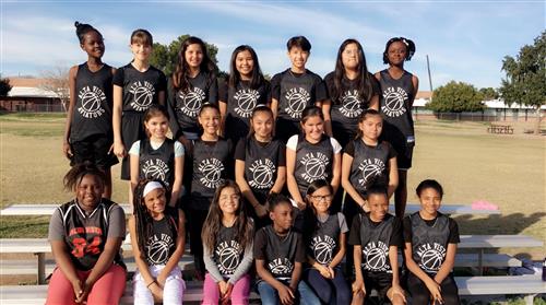 a girls basketball team in black jerseys