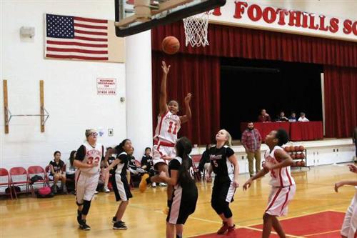 a girls basketball team about to score a point