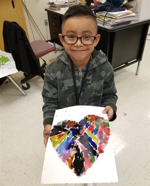 student shows off his painting