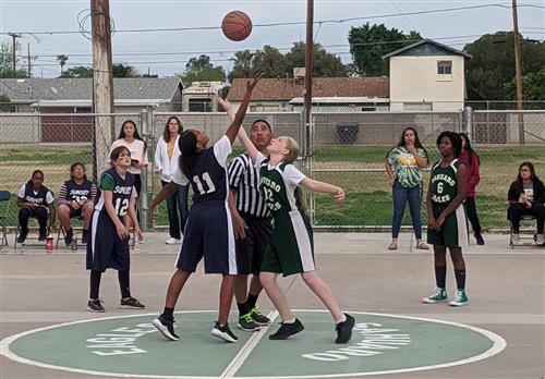 The girls basketball team plays against another school