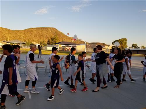 sudents high five after a basketball game