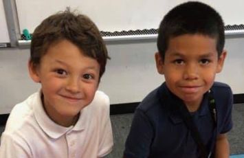  two students smile at the camera